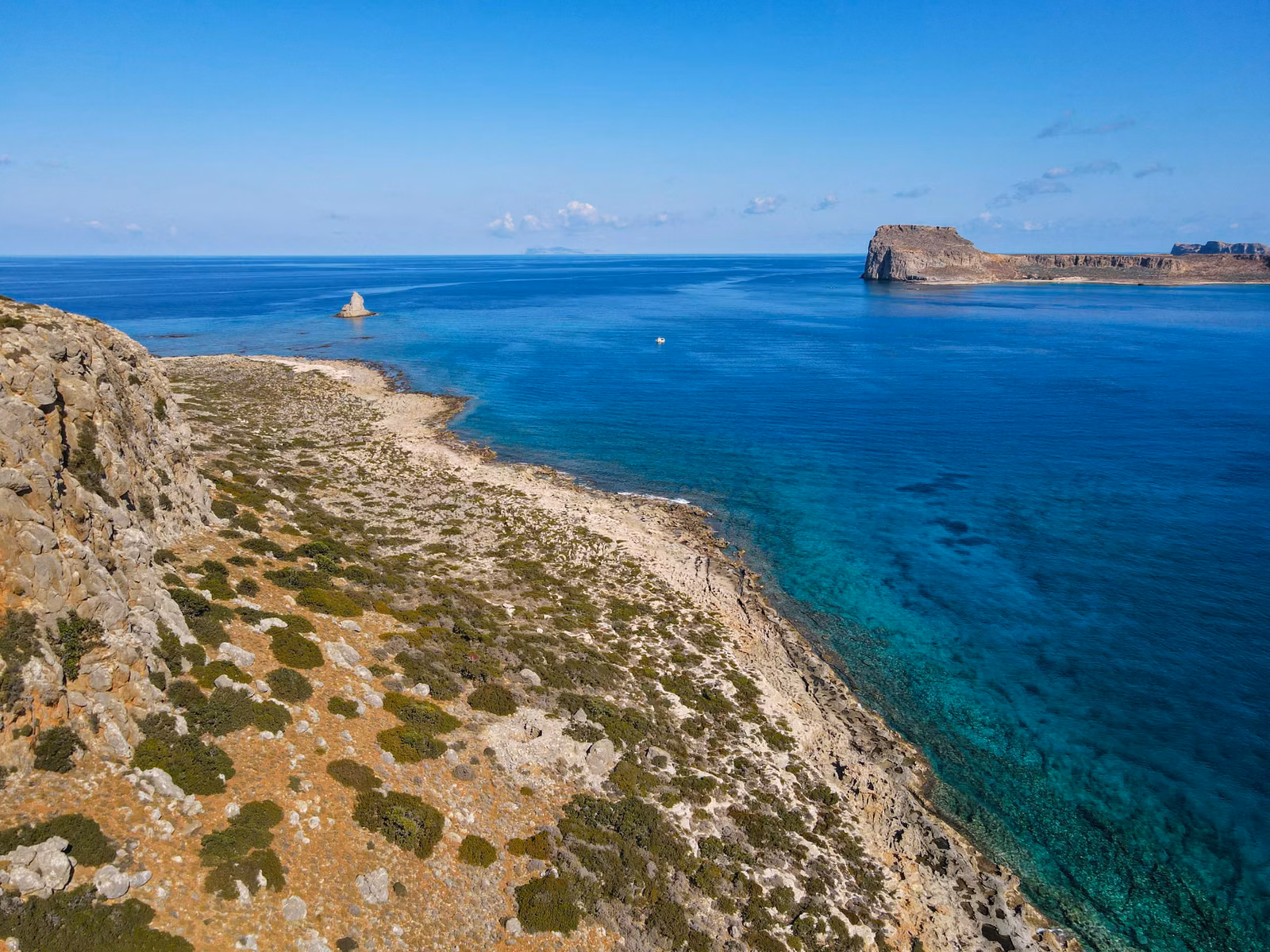Aerial view of a rocky Los Cabos headland meeting turquoise Pacific water.