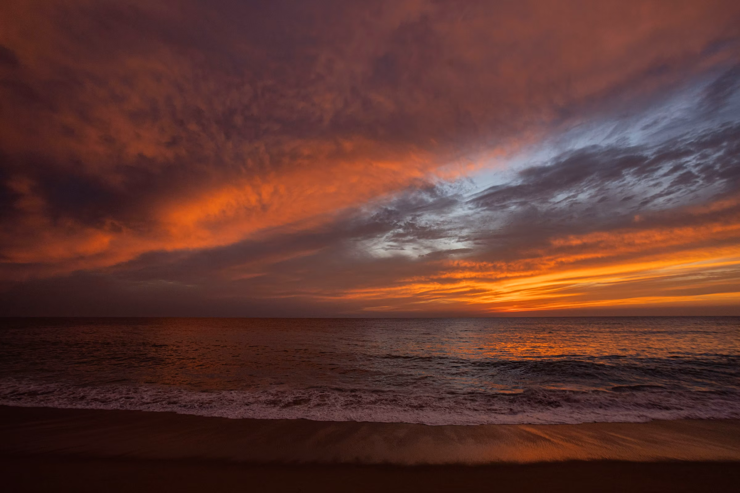 Dramatic sunset over a calm Pacific Ocean with colorful clouds