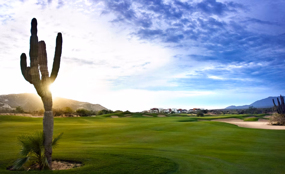 Golfer on a desert mountain course with ocean views at golden hour, Club Campestre lifestyle, San José del Cabo