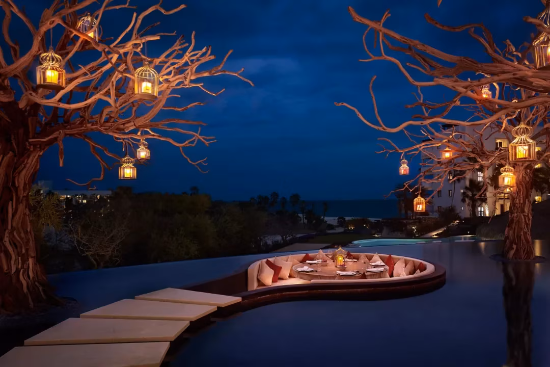 Curved oceanfront resort pool at golden hour with the Sea of Cortez beyond, Las Ventanas al Paraíso lifestyle, Los Cabos